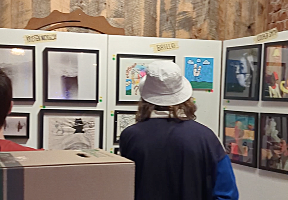 Guests looking at white gallery walls with a mixed variety of art hung up