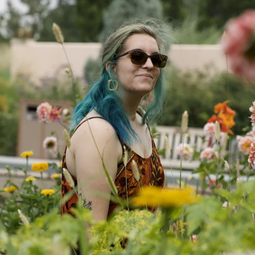 Headshot of Side Hustle Art Show artist, Emily LaCroix in a field of flowers